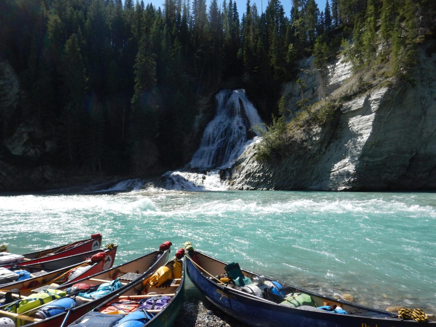 canoees by beautiful waterfall